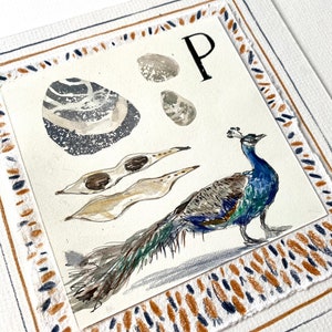 P es para pavo real, guijarro y vaina, ilustración original firmada con letras de la A a la Z por Camilla Seddon montada en una tabla de montaje adornada a mano
