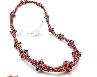 May include: A beaded necklace with the text "STRIPED BAMBOO". The necklace features a repeating pattern of orange, black, and iridescent beads. The necklace is displayed on a white background.