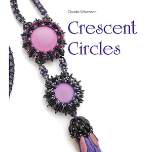 May include: A beaded necklace with a large, round, light purple center stone, surrounded by black and red beads. The necklace has a matching pendant with a tassel of purple threads. The book cover features the title "Crescent Circles".