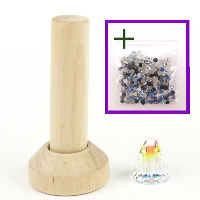 May include: A wooden spool with a base, a small clear crystal, and a bag of blue and silver rhinestones.