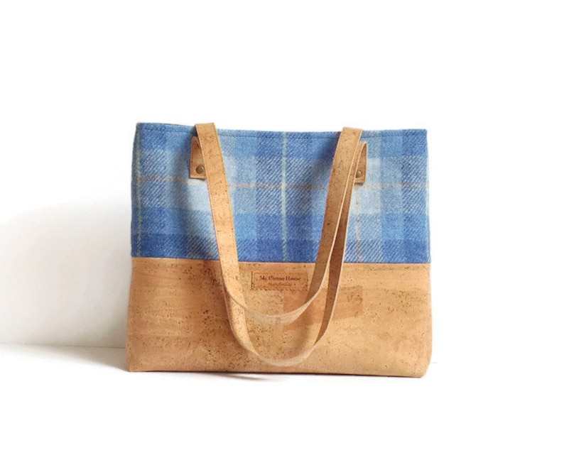 May include: A blue and white plaid tote bag with cork bottom and leather straps. The bag has a label that reads "Mr. Charles Hower Handmade in Scotland".