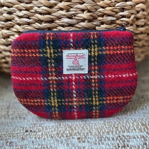 K&ouml;nnte beinhalten: Rote, schwarze und gelbe karierte Rei&szlig;verschlusstasche aus Harris Tweed Stoff. Die Tasche hat ein Etikett mit der Aufschrift "Hand Woven Cloth Harris Tweed Outer Hebrides of Scotland 100% Pure New Wool."