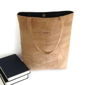 May include: A cork tote bag with black polka dot lining and a brown leather label that says "My Cotton House Handmade".