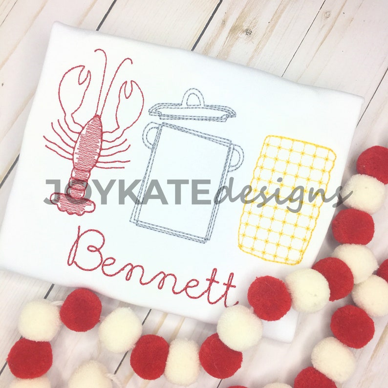 May include: Embroidered white t-shirt with a red lobster, a gray pot with a lid, and a yellow checkered pattern. The name "Bennett" is embroidered in red below the design.