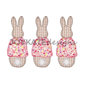 May include: Three brown and white gingham bunny rabbits with pink floral print dresses. The bunnies are standing in a row.