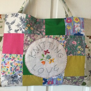 May include: A patchwork tote bag featuring a mix of floral and animal prints. The bag has a large embroidered circle in the centre that reads "Knitting Love".