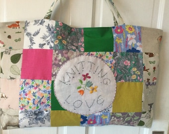 May include: A patchwork tote bag with a variety of floral and animal prints. The bag has a large embroidered circle in the center that says "Knitting Love".