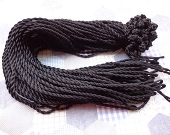 May include: A large bundle of black twisted cord, with a knotted end.
