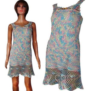 May include: A sleeveless crochet dress with a light blue, pink, and yellow pattern. The dress has a fitted bodice and a flared skirt.