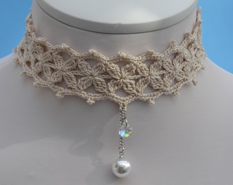 May include: A delicate crocheted choker necklace with a floral design. The necklace features a crystal and pearl pendant.