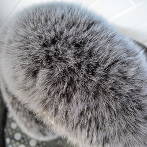 K&ouml;nnte beinhalten: Nahaufnahme eines grauen Pelzbommels. Das Fell ist weich und flauschig, und der Bommel ist rund und voll.