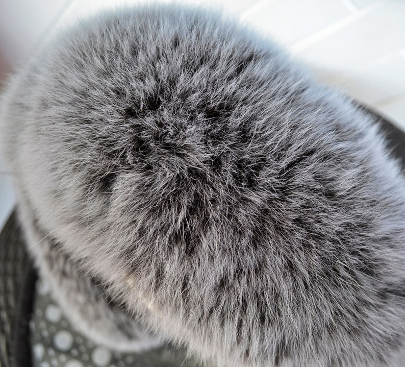 K&ouml;nnte beinhalten: Nahaufnahme eines grauen Pelzbommels. Das Fell ist weich und flauschig, und der Bommel ist rund und voll.