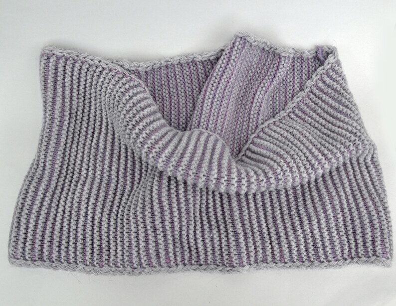 May include: A gray and purple striped knitted scarf with a ribbed texture.