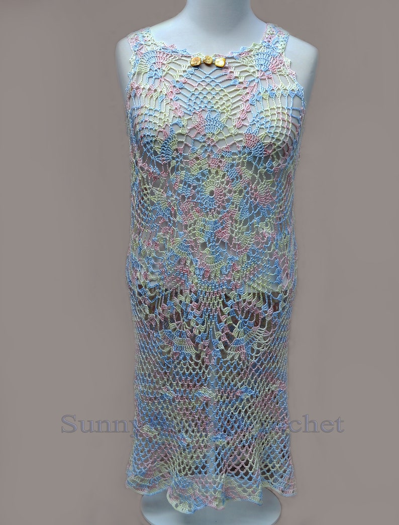 May include: A crocheted dress in a light blue, pink, and yellow color scheme. The dress has a delicate floral pattern and a scalloped hem.