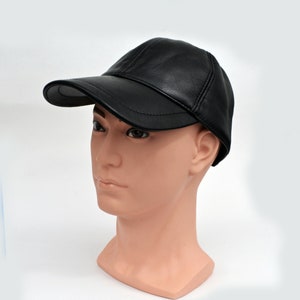 Puede incluir: Una gorra de b&eacute;isbol de cuero negro con visera curva. La gorra est&aacute; en una cabeza de maniqu&iacute;.