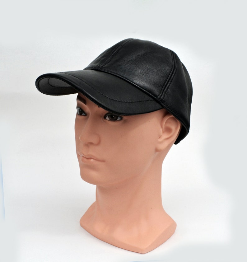 Puede incluir: Una gorra de b&eacute;isbol de cuero negro con visera curva. La gorra est&aacute; en una cabeza de maniqu&iacute;.