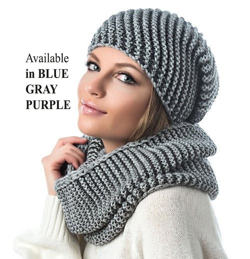 May include: A gray and black striped knit beanie and matching infinity scarf. Available in blue, gray, and purple.