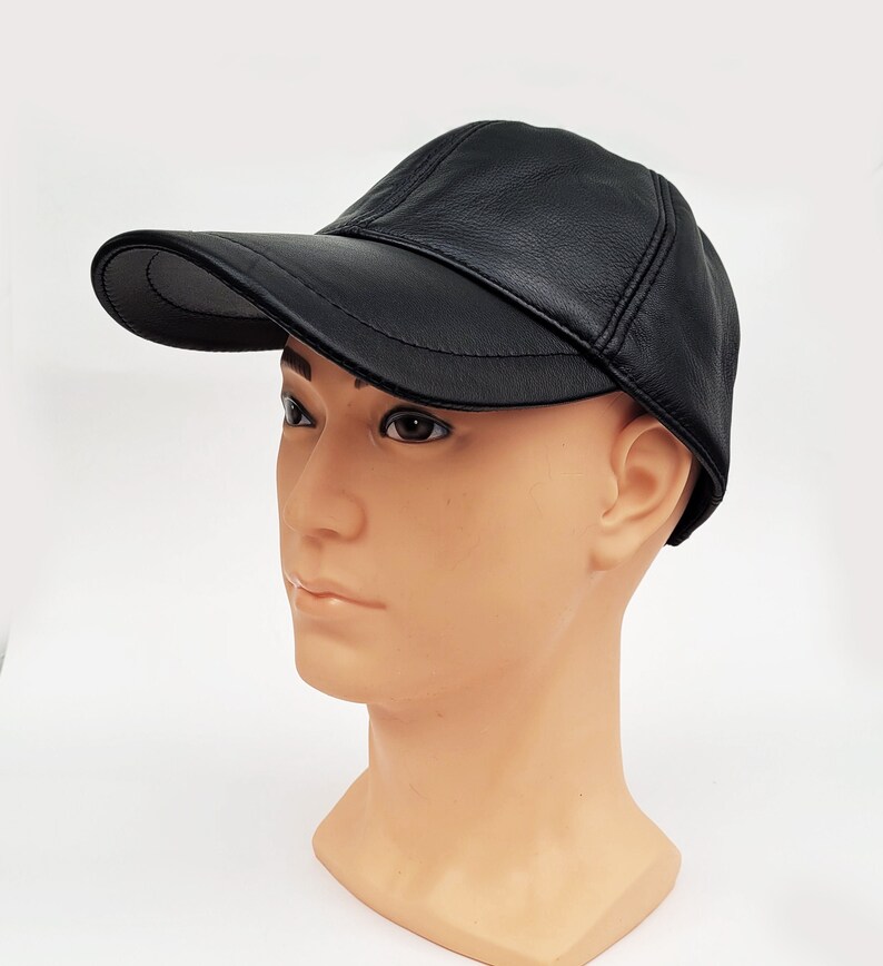 Puede incluir: Una gorra de b&eacute;isbol de cuero negro con visera curva. La gorra est&aacute; en una cabeza de maniqu&iacute;.