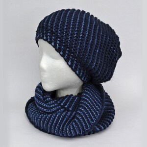 May include: A blue and dark blue striped knit hat and matching scarf set. The hat is slouchy and the scarf is a cowl style.