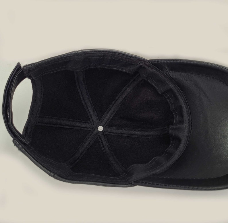 Puede incluir: Gorra de b&eacute;isbol de cuero negro con forro de tela negro. La gorra tiene un dise&ntilde;o cl&aacute;sico de seis paneles y una visera curvada.
