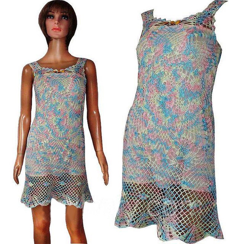 May include: A sleeveless crochet dress with a light blue, pink, and yellow pattern. The dress has a fitted bodice and a flared skirt.
