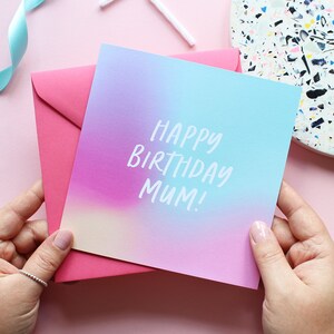 May include: A pink and blue ombre birthday card with the text "Happy Birthday Mum!" in white.