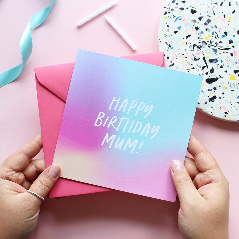 May include: A pink and blue ombre birthday card with the text "Happy Birthday Mum!" in white.