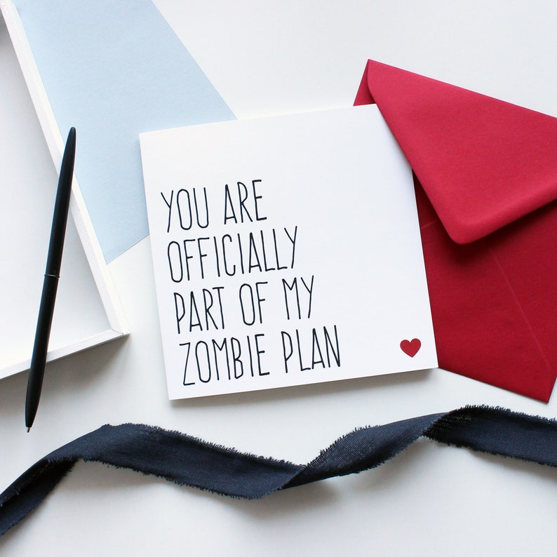 Valentines day card that reads you are officially part of my zombie plan with a red heart in the bottom corner. Red envelope.