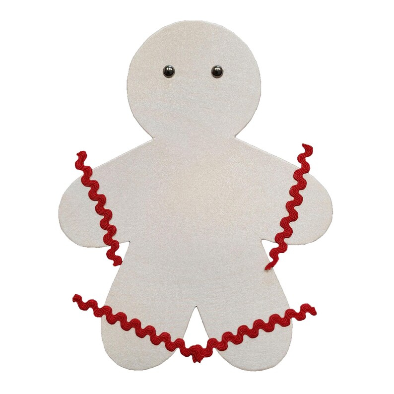 May include: A white gingerbread man cutout with red curly trim around the edges and two black eyes.