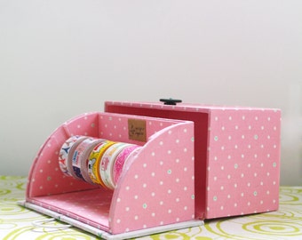 May include: Pink polka dot box with a lid that opens to reveal a compartment for storing washi tape. The box has a small label that says "Love's Simple Things".