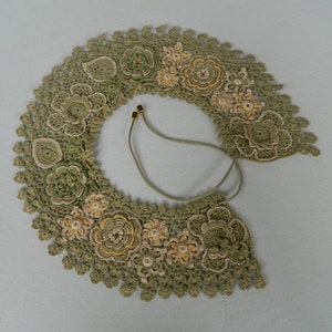 May include: A green crocheted collar with delicate floral designs and a brown leather cord.