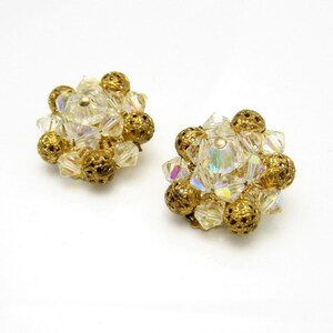 May include: A pair of gold tone clip-on earrings with iridescent clear glass beads and gold tone balls.