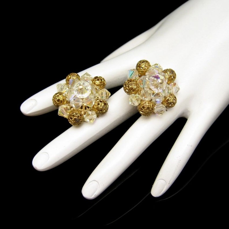 May include: A pair of gold tone clip-on earrings with clear iridescent glass beads and gold tone balls.