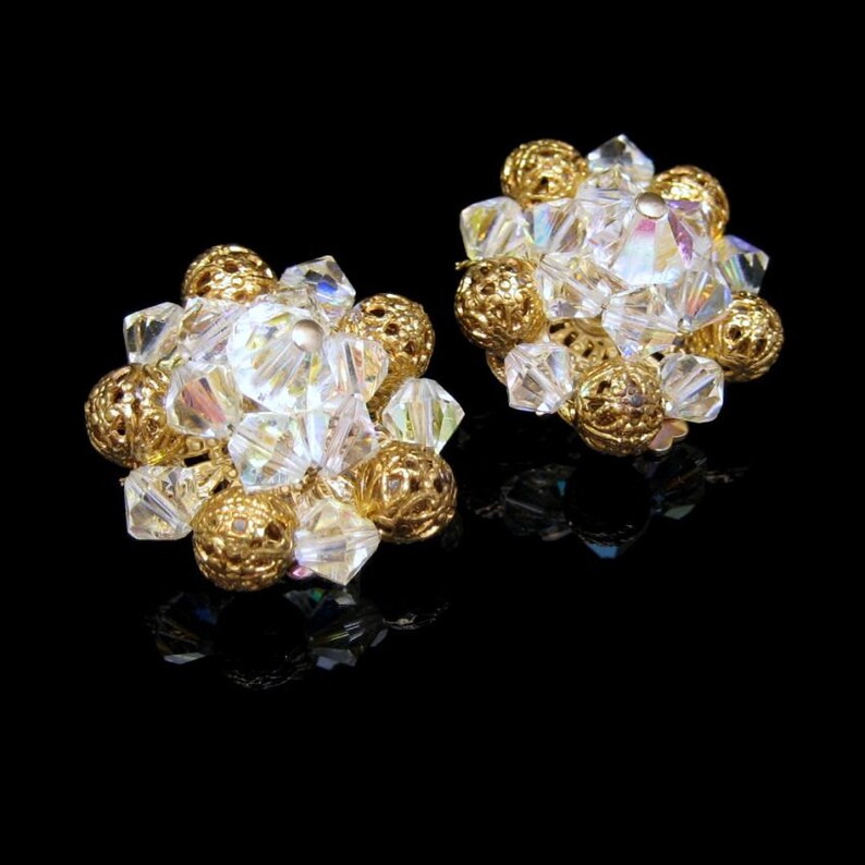 May include: A pair of gold tone clip-on earrings with clear iridescent crystal beads.