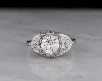 Antik / Vintage / Gods ca 1920-talet Post-edwardiansk, art déco-förlovningsring med utsmyckade spadeaxlar; övergångsslipad diamant i mitten