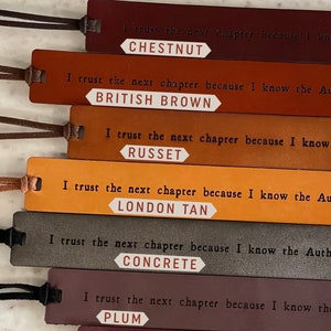 May include: Six leather bookmarks with different colors and the text "I trust the next chapter because I know the Author." and the color name of the bookmark below the text. The colors are Chestnut, British Brown, Russet, London Tan, Concrete, and Plum.