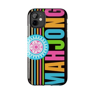 May include: Black phone case with the word "MAHJONG" in large, colorful letters. The case has a striped design with pink, orange, yellow, and blue vertical lines. A circular emblem with a flower design is on the left.