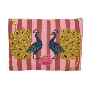 May include: A rectangular pouch with a pink and red striped background. Two navy blue peacocks with gold and yellow tail feathers face each other. A pink lotus flower is between them. Gold rope-like accents and a gold zip.