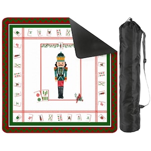 Puede incluir: Una esterilla de Mahjong blanca y roja con un borde verde y una bolsa de transporte negra. La esterilla presenta una ilustraci&oacute;n de cascanueces y fichas de Mahjong. La esterilla es rectangular y tiene un borde rojo y verde.