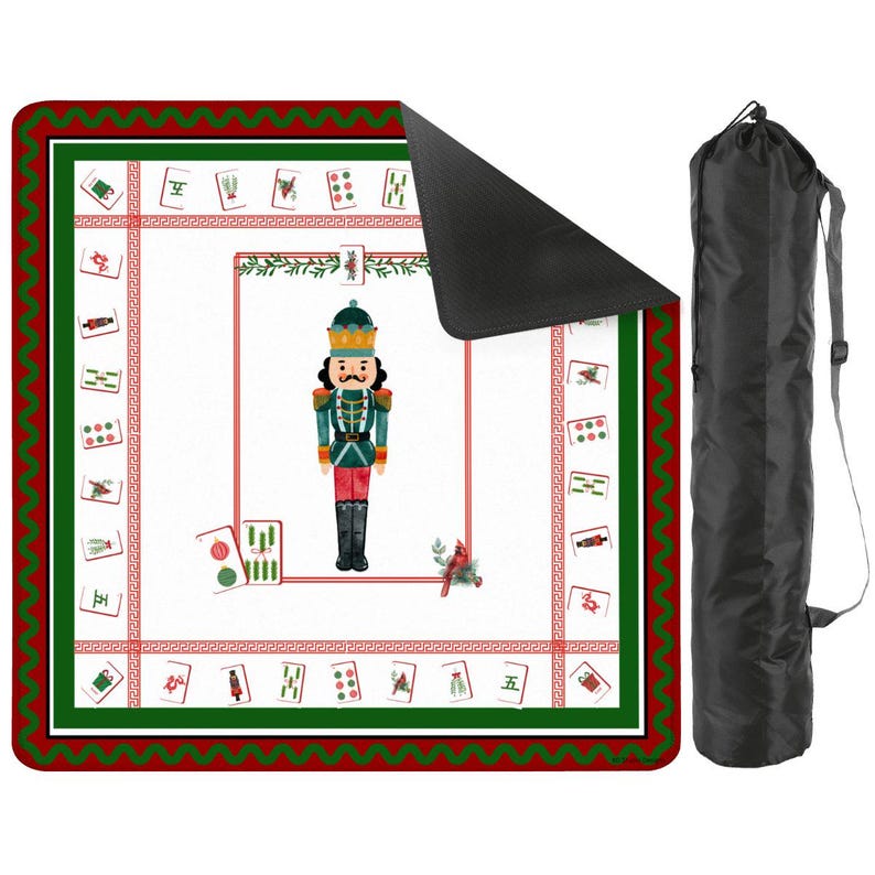 Puede incluir: Una esterilla de Mahjong blanca y roja con un borde verde y una bolsa de transporte negra. La esterilla presenta una ilustraci&oacute;n de cascanueces y fichas de Mahjong. La esterilla es rectangular y tiene un borde rojo y verde.