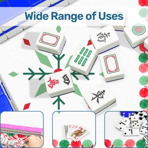 May include: A collection of white Mahjong tiles with various symbols and colors, including red, green, and black. The tiles are scattered on a white surface with a snowflake design. The image also shows playing cards and dominoes, suggesting a game theme.