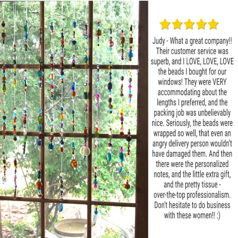 May include: A window with colorful beaded curtains hanging from the top. The beads are made of glass and are in various shapes and sizes. The beads are strung on clear thread and are hanging in front of a window with a green leafy background. The text in the image reads: "Judy - What a great company!! Their customer service was superb, and I LOVE, LOVE, LOVE the beads I bought for our windows! They were VERY accommodating about the lengths I preferred, and the packing job was unbelievably nice. Seriously, the beads were wrapped so well, that even an angry delivery person wouldn't have damaged them. And then there were the personalized notes, and the little extra gift, and the pretty tissue - over-the-top professionalism. Don't hesitate to do business with these women!! :)"