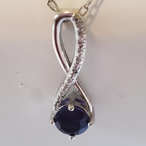 PAJ 88 Amethyst Infinity necklace and earrings set. Silver chain 18 in. Pendant drop 1 in. Matching fish Hook earrings.
