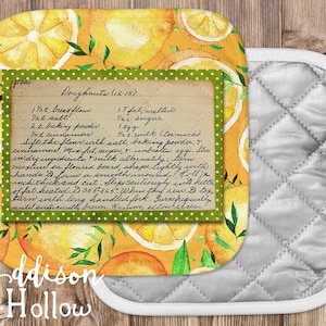 May include: A yellow and green pot holder with a vintage recipe for doughnuts printed on it. The recipe includes ingredients like bread flour, salt, baking powder, cinnamon, fat, sugar, eggs, and milk. The pot holder is decorated with a watercolor pattern of lemons and leaves.