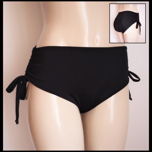 May include: Black high-waisted bikini bottoms with adjustable side ties. The bottoms have a smooth, sleek fabric and a high-cut leg.