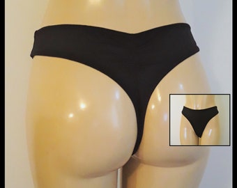 May include: Black thong underwear with a low-rise cut. The underwear is made of a smooth, stretchy fabric.