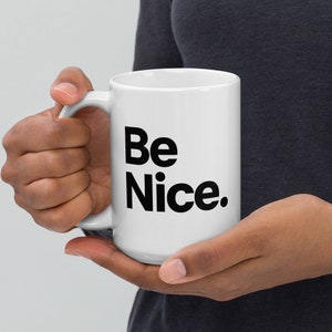 May include: White ceramic mug with a black inscription that reads "Be Nice."