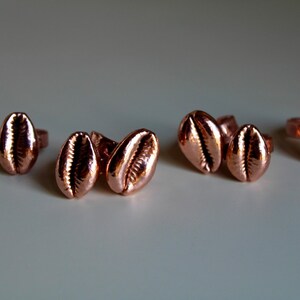 May include: Set of six rose gold shell-shaped earrings. The earrings are small and delicate, and they would make a great gift for someone who loves the beach.