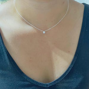 May include: A delicate silver necklace featuring a small, square-shaped charm. The necklace is worn against a dark blue top. Text on the image reads "4mm charm Style #3".