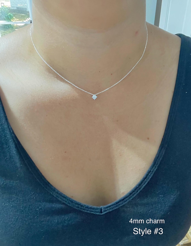 May include: A delicate silver necklace featuring a small, square-shaped charm. The necklace is worn against a dark blue top. Text on the image reads "4mm charm Style #3".
